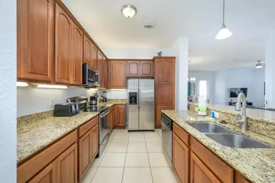 a kitchen with wooden cabinets and stainless steel appliances at Beautiful Lakeview Vacation Condo, Vista Cay 1016 in Orlando