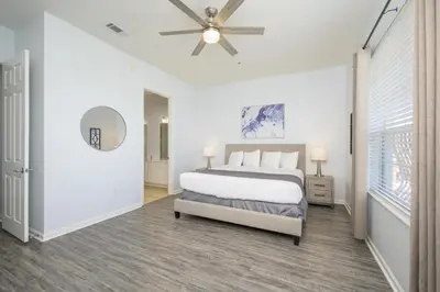 a white bedroom with a bed and a ceiling fan at Beautiful Lakeview Vacation Condo, Vista Cay 1016 in Orlando