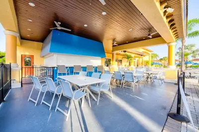 a patio with white tables and chairs on a building at This Happy Place in Kissimmee
