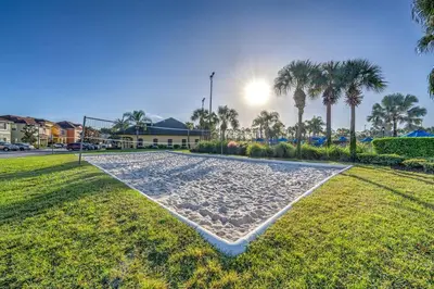 a beach in the grass with palm trees in the background at This Happy Place in Kissimmee