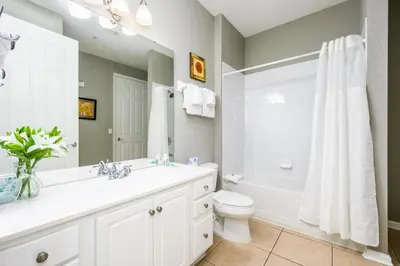 a bathroom with a sink and a toilet and a tub at Epic Universe Family Fun Vista Cay Lakeview Condo - 1021 in Orlando