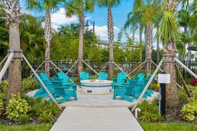 a group of blue chairs on a patio with palm trees at Epic Universe Family Fun Vista Cay Lakeview Condo - 1021 in Orlando