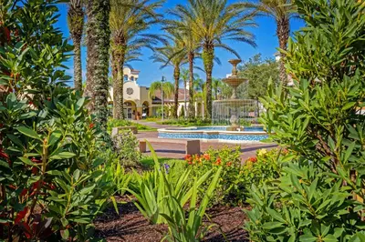 a garden with a fountain and palm trees at Beautiful Lakeview Condo, New Listing -1024 in Orlando