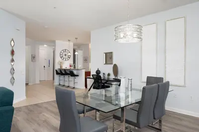 a dining room with a glass table and chairs at Epic Universe Large Condo With Pool Table, Vista Cay - 2003 in Orlando