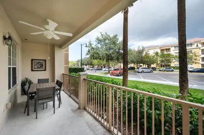 a balcony with a table and chairs and a street at Epic Universe Large Condo With Pool Table, Vista Cay - 2003 in Orlando