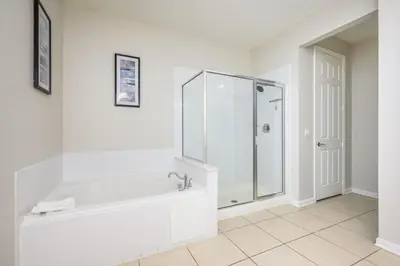 a white bathroom with a shower and a tub at Premium Vista Cay Condo, Vista Cay - 2006 in Orlando