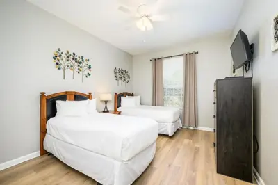a bedroom with two beds and a flat screen tv at Vista Cay Deluxe Condo, Near The Parks! - 3002 in Orlando