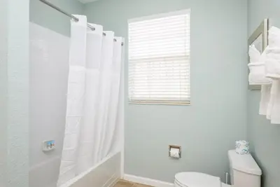 a white bathroom with a shower and a toilet at Beautiful Deluxe Condo, Vista Cay, Orlando - 3008 in Orlando