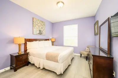a bedroom with a large bed and purple walls at Vista Cay Deluxe Condo, Vista Cay - 3010 in Orlando