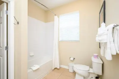 a white bathroom with a toilet and a shower at Epic Universe New Beautiful Condo, Vista Cay, Orlando - 3011 in Orlando