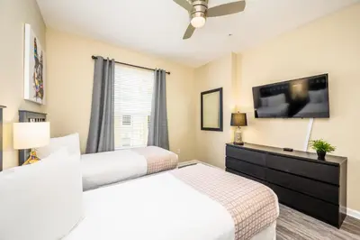a bedroom with two beds and a flat screen tv at Epic Universe New Beautiful Condo, Vista Cay, Orlando - 3011 in Orlando