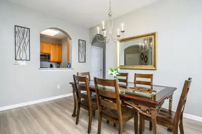 a dining room with a table and chairs and a mirror at Epic Universe Beautiful Lakeview Condo, Vista Cay Orlando - 3013 in Orlando