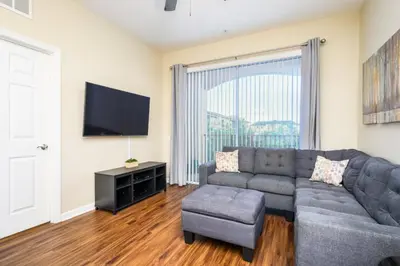 a living room with a couch and a flat screen tv at Beautiful Deluxe Condo, Vista Cay - 3023 in Orlando