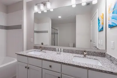a bathroom with two sinks and a large mirror at New Modern Vista Cay Reserve Condo - 6007 in Orlando
