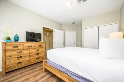 a bedroom with a white bed and a tv on a dresser at Epic Universe New Modern Townhome, Near The Parks - 4029 in Orlando