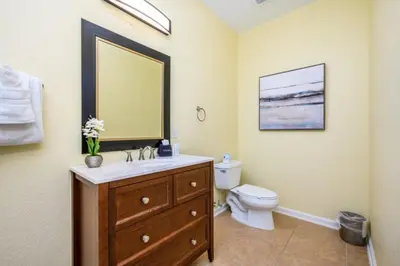a bathroom with a sink and a toilet and a mirror at New Modern Townhome, Near The Parks - 4030 in Orlando
