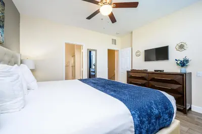 a bedroom with a white bed and a ceiling fan at Epic Universe Beautiful Vacation Townhome - 4031 in Orlando