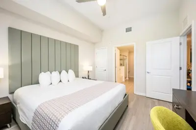 a bedroom with a large white bed and two chairs at Top Floor Modern Vista Cay Reserve Condo - 5004 in Orlando