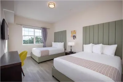 a hotel room with two beds and a desk at New Modern Vista Cay Reserve Condo - 6006 in Orlando