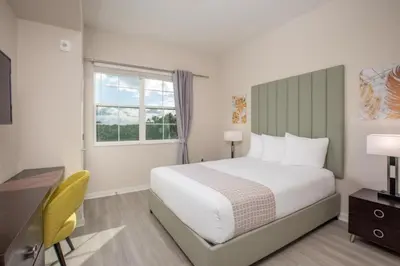 a bedroom with a bed and a desk and a window at New Modern Vista Cay Reserve Condo - 6006 in Orlando