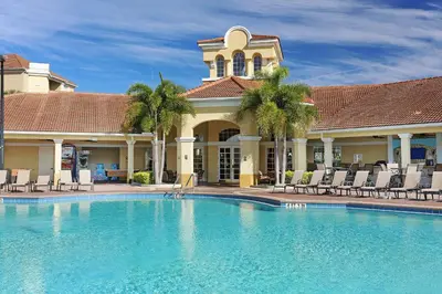a pool in front of a house with chairs and a building at New Modern Vista Cay Reserve Condo - 6006 in Orlando