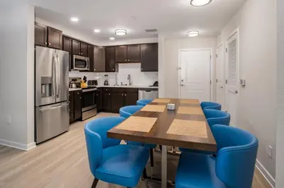 a kitchen with a wooden table and blue chairs at New Modern Vista Cay Reserve Condo - 6006 in Orlando