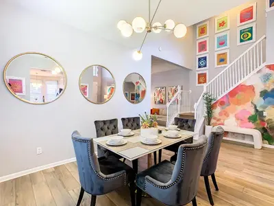 a dining room with a table and chairs and mirrors at WH7820BS - 5 bedrooms - Pool - Theater - Resort in Orlando