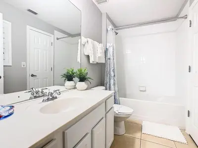 a white bathroom with a sink and a toilet at WH7820BS - 5 bedrooms - Pool - Theater - Resort in Orlando