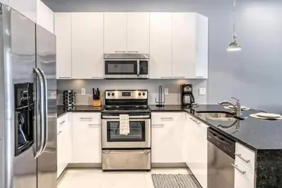 a kitchen with white cabinets and a stove and a microwave at Pond view pool home close to Disney TR17508PA - 3 bedrooms - 3 bath - waterview in Orlando