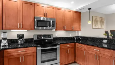 a kitchen with wooden cabinets and a microwave at Ultimate Summer Retreat - TownHome by Disney! in Orlando