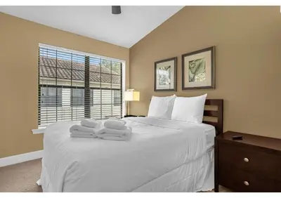 a bedroom with a large white bed with towels on it at Summer Days Fun - Renovated TownHome by Disney! in Orlando