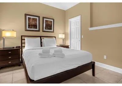 a bedroom with a large bed with towels on it at Summer Days Fun - Renovated TownHome by Disney! in Orlando