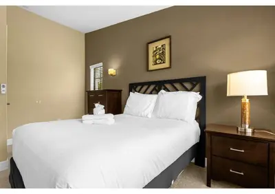 a bedroom with a large white bed and a nightstand at Summer Days Fun - Renovated TownHome by Disney! in Orlando