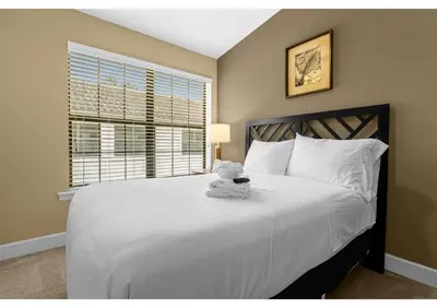 a bedroom with a white bed with a teddy bear on it at Summer Days Fun - Renovated TownHome by Disney! in Orlando