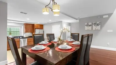 a dining room with a table and chairs and a kitchen at Book Your Summer Escape - TownHome by Disney! in Orlando