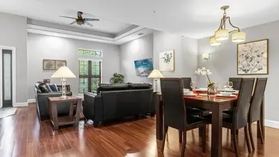 a dining room and living room with a table and chairs at Book Your Summer Escape - TownHome by Disney! in Orlando