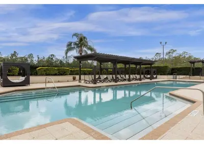 a large swimming pool with a gazebo at Book Your Summer Escape - TownHome by Disney! in Orlando