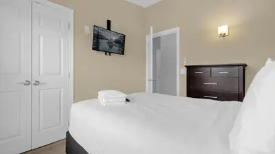 a bedroom with a white bed and a dresser at Sunny Summer in Orlando - TownHome by Disney! in Orlando