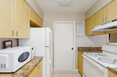 a kitchen with a microwave and a white refrigerator at Pool Access! Dog-Friendly Retreat 16 Mi to Orlando in Orlando
