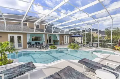 a large swimming pool with a glass roof at Mickeys Oyster - Luxurious 9BR Southeast Facing Pool Hot Tub Cinema Game RM BBQ 2 miles to Disney in Orlando