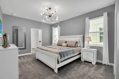 a bedroom with a bed and a mirror and a chandelier at Magical Mickey Home 8 minutes from Disney STL109 in Kissimmee