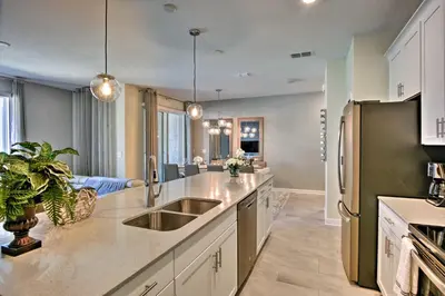 a kitchen with a sink and a refrigerator at The Windermere - Pool Lazy River & Waterslides in Kissimmee