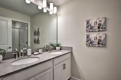 a bathroom with two sinks and a large mirror at The Windermere - Pool Lazy River & Waterslides in Kissimmee