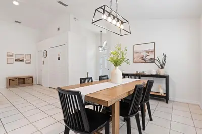 a dining room with a wooden table and black chairs at Indian Ridge - Pool Home with Spa, Newly Renovated in Orlando