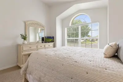 a bedroom with a large bed and a large window at Indian Ridge - Pool Home with Spa, Newly Renovated in Orlando