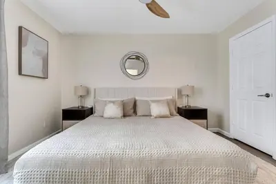 a white bedroom with a large white bed with a mirror at Immersive Themed Villa in Resort 4mi to Disney with Game Room and Private Pool in Orlando