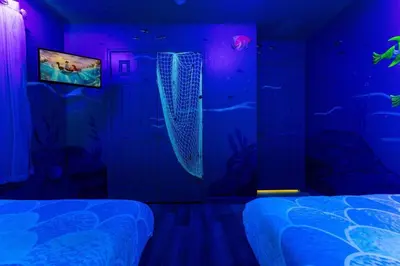 a room with two beds and a fish tank at Immersive Themed Villa in Resort 4mi to Disney with Game Room and Private Pool in Orlando