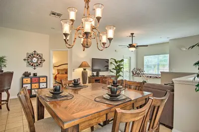 a dining room and living room with a table and chairs at Quiet Disney Condo w/ Balcony ~ 2 Miles to Disney World! in Orlando