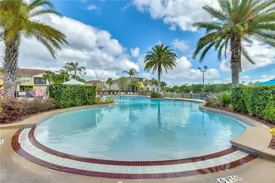 a swimming pool in a resort with palm trees at Quiet Disney Condo w/ Balcony ~ 2 Miles to Disney World! in Orlando