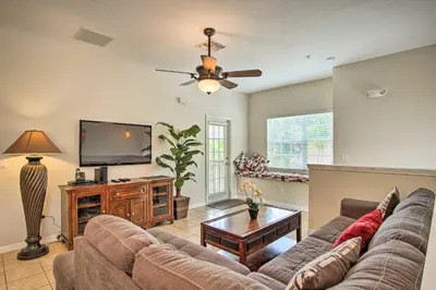 a living room with a couch and a flat screen tv at Quiet Disney Condo w/ Balcony ~ 2 Miles to Disney World! in Orlando